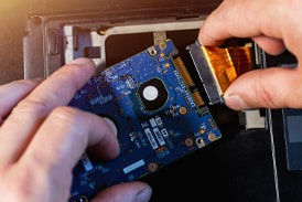 Picture of computer technician replacing hard drive in computer