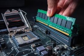 Picture of computer repair man replacing RAM memory chip with a new one